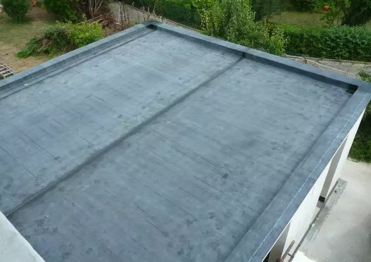 toiture plate couverte en membrane EPDM vue prise en hauteur, autour du toit on distingue un jardin et un terrasse.