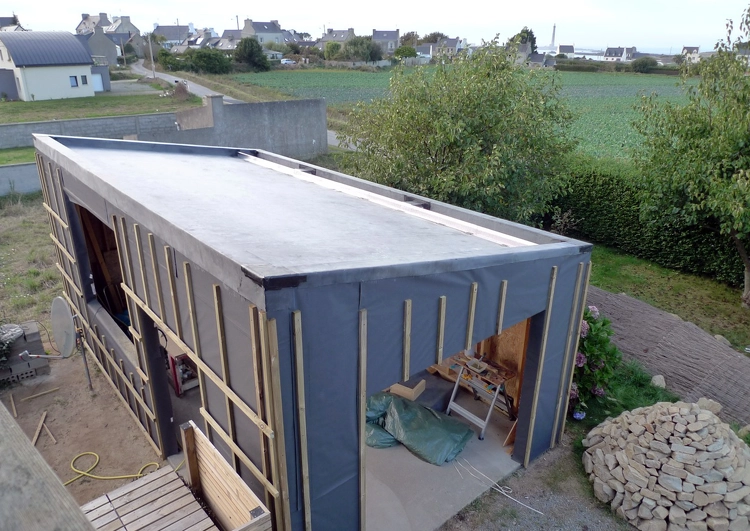 chantier d'un garage en ossature bois avec toiture en pente douce couverte en membrane EPDM avant la pose du système de végétalisation.